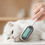 Cepillo para mascotas ergonómico eliminando el pelo muerto de un gato blanco de forma suave y eficaz.