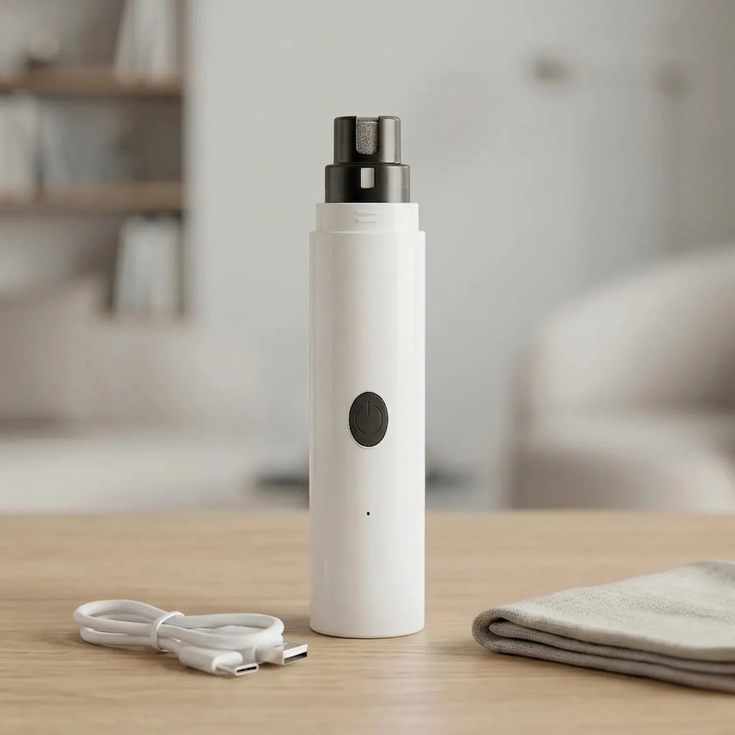 Lima de uñas para perros recargable mediante cable USB sobre una mesa de madera en casa.